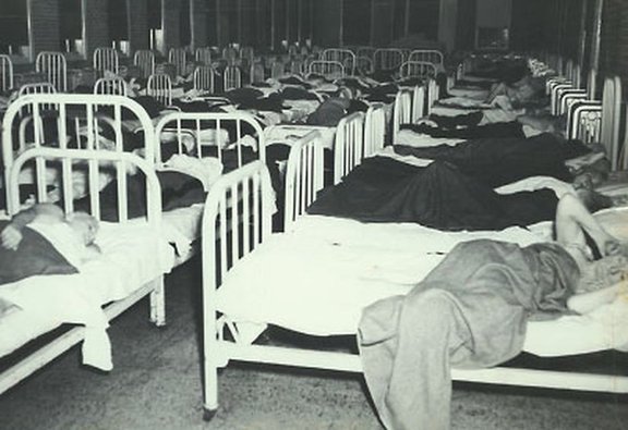 Photographie d&rsquo;un asile publiée en 1961 dans une revue scientifique. L&rsquo;absence d&rsquo;intimité est manifeste. Comment imaginer une thérapie sereine et individualisée dans ce contexte ? (source)