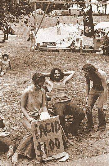 Photographie prise à Woodstock. On y voit trois personnes proposant une dose de LSD contre 1$.
